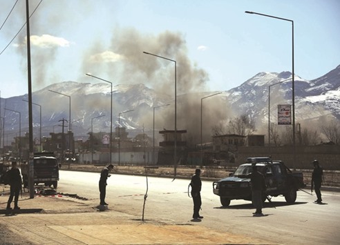 Smoke rises as Afghan security force members stand guard near the site of an attack in Kabul last Wednesday. A suicide bombing rocked western part of the Afghan capital Kabul, followed by a gun battle.