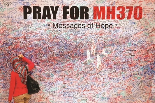 A woman leaves a message of support and hope for the passengers of the missing Malaysia Airlines MH370 in central Kuala Lumpur.