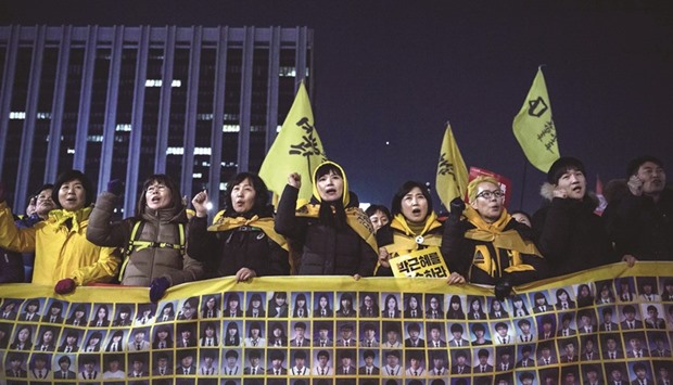 Relatives of victims of the 2014 Sewol ferry disaster join anti-government activists during a rally in Seoul yesterday.