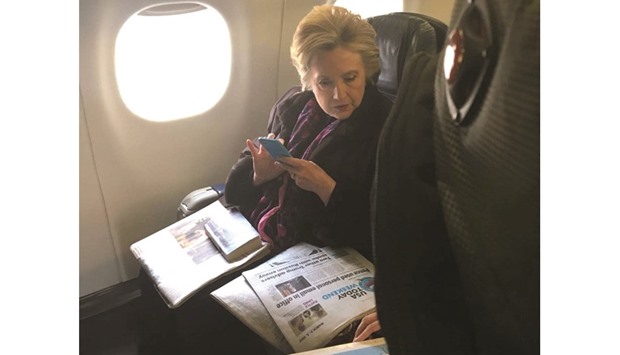 Clinton looks at a USA Today newspaper carrying an article about Vice-President Penceu2019s use of personal e-mail while he was a state governor, during her flight on American Airlines to Laguardia airport in New York City.