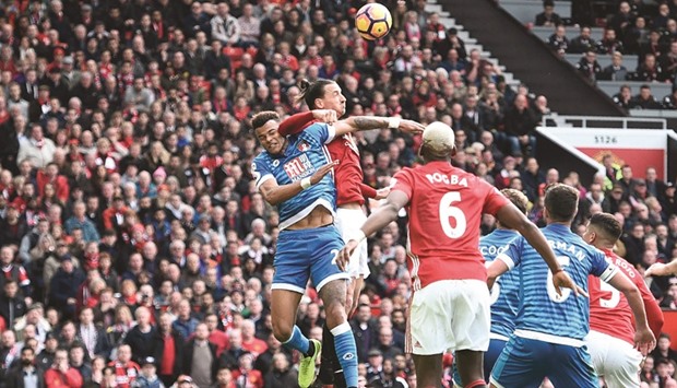 Manchester Unitedu2019s Swedish striker Zlatan Ibrahimovic (2L) clashes in the air with Bournemouthu2019s English defender Tyrone Mings (L) during their English Premier League match yesterday.