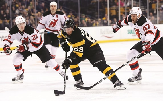 Boston Bruins left wing Brad Marchand (second from right) breaks between New Jersey Devils defensemen Damon Severson (left) and Dalton Prout (right) during their NHL game in Boston on Saturday. (USA TODAY Sports)