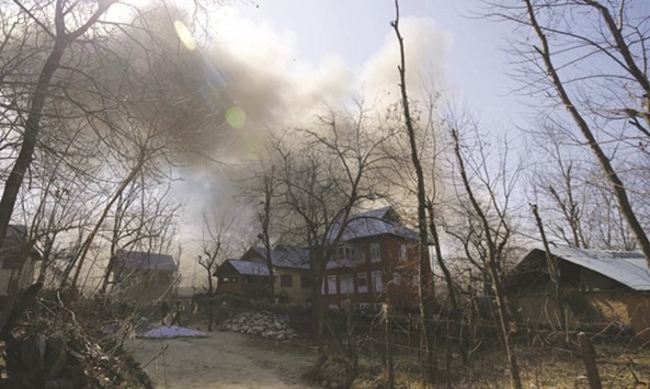 Smoke and dust billows from the residential house in which suspected militants were holed up during a gunfight.