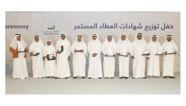 Al-Kaabi with employees who have achieved a u201ccareer milestoneu201d of 40 years of service with QP.