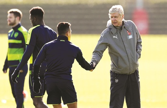 Arsenal manager Arsene Wenger shakes hands with Arsenalu2019s Alexis Sanchez during training yesterday.