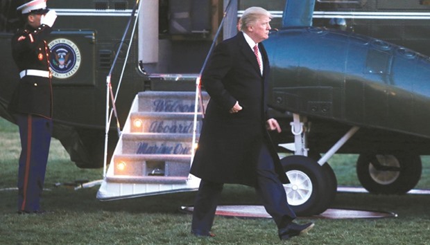 President Donald Trump walks from Marine One as he returns to the White House in Washington.