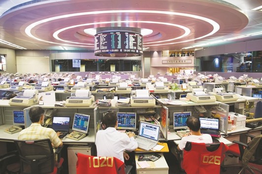 Traders work at the Hong Kong Stock Exchange. The Hang Seng closed up 0.4% to 23,681.07 points yesterday.