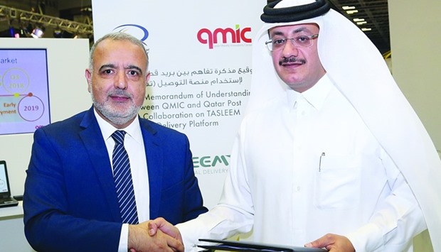 QMIC's Dr Adnan Abu-Dayya and Q-Post's Faleh Mohamed al-Naemi shake hands after signing the agreement yesterday to implement Tasleem. PICTURE: Jayan Orma