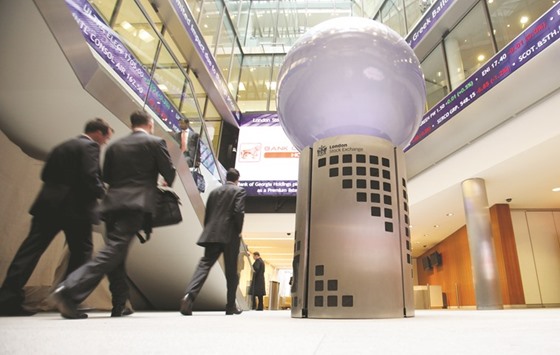 Visitors pass a sign inside the London Stock Exchange. The FTSE 100 closed down 0.2% to 7,338.99 points yesterday.
