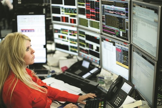 A trader works at the London Stock Exchange. The FTSE 100 yesterday lost 0.1% to 7,334.61 points.