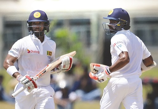 Sri Lankan cricketers Kusal Mendis (L) and Niroshan Dickwella run between the wickets during the second day of the opening Test against Bangladesh in Galle yesterday.