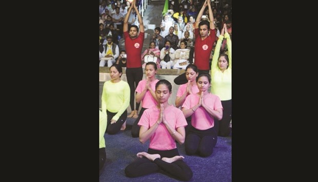 Men and women perform yoga during the inauguration of the International Yoga Fest in New Delhi yesterday.