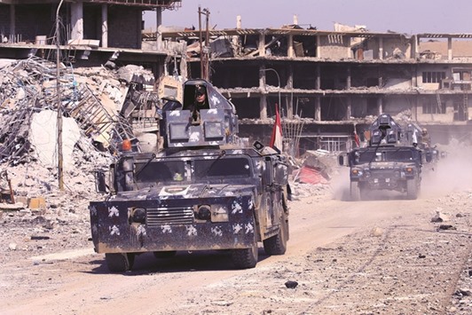 Military vehicles of federal police are seen during a battle with Islamic State militants at Dawasa neighbourhood in Mosul, Iraq yesterday.