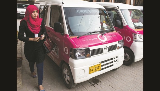 A driver with the women-only Paxi Pakistan taxi company walks past a Pink Taxi during a launching ceremony in Karachi yesterday, on International Womenu2019s Day.