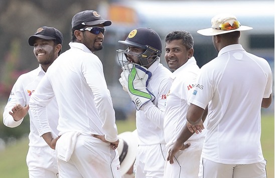 Sri Lankan spinner Rangan Herath (2R) celebrates with teammates after he dismissed Bangladeshu2019s Mushfiqur Rahim during the third day of the opening Test in Galle yesterday. (AFP)