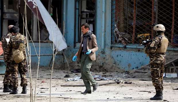 Afghan officials investigate the site of a suicide bomb attack near a Shia mosque in Kabul