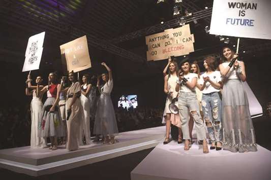 Models carry placards as they present creations by Pakistani designer Hira Ali on Friday, the first day of the Pakistan Fashion Design Council (PFDC) Fashion Week in Lahore. International Womenu2019s Day was marked on Thursday.