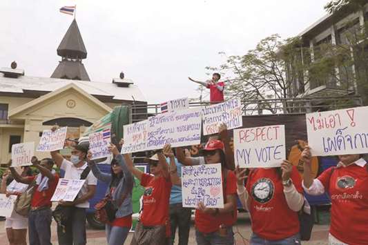 Thai anti-junta activists display placards during a pro-democracy rally at a university field in Bangkok.