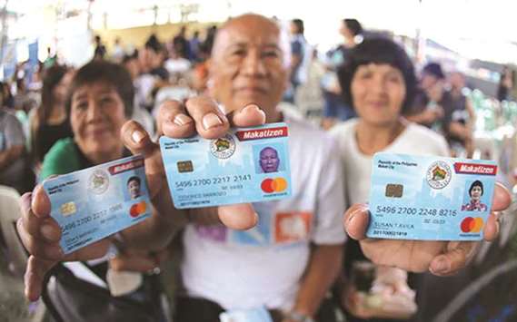 Makati residents show their Makatizen Card which was distributed in villages yesterday. The card enables residents to have easier public transactions.