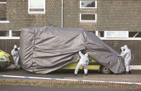 Personnel in protective coveralls and breathing equipment cover an ambulance with a tarpaulin at the Salisbury District Hospital in Salisbury, southern England, yesterday in connection with the major incident sparked after a man and a woman were apparently poisoned in a nerve agent attack.