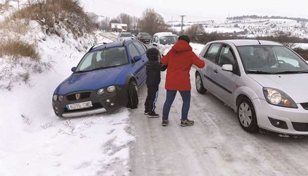 A woman asks for help after her car was stuck in the snow after a heavy snowfall in Burgos, northern Spain.