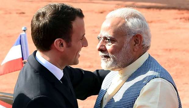 India's Prime Minister Narendra Modi (R) greets France's President Emmanuel Macron