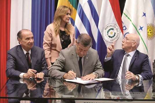 Uruguayan Foreign Minister Rodolfo Nin Novoa signs a document alongside Brazilian Foreign Minister Aloysio Nunes Ferreira (left) and Paraguayan Foreign Minister Eladio Loizaga (right) during a meeting between Canada and the Mercosur trade bloc at Paraguayu2019s Foreign Ministry building in Asuncion on Friday.
