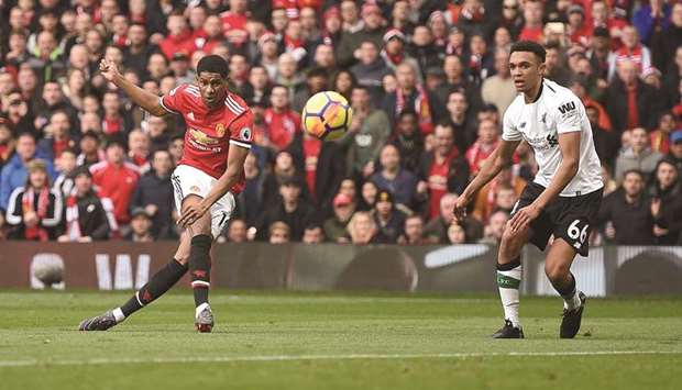 Manchester Unitedu2019s English striker Marcus Rashford (L) scores the opening goal during his team's English Premier League football match against Liverpool at Old Trafford yesterday.