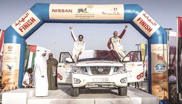 Qataru2019s Adel Abdulla (right) and co-driver Nasser al-Kuwari celebrate after clinching second position in the T2 race  at the Dubai International Baja yesterday. They now lead the World Championship.