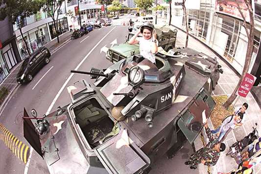 A woman poses for a selfie on an armoured personnel carrier during the information caravan mounted by the Philippine Army. The event held at the Bonifacio Global City is part of the month-long celebration of he Armyu2019s 121st anniversary.
