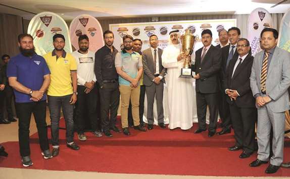 Qatar Cricket, Rugby and Hockey Federation (QCRHF) president Yousef Jeham al-Kuwari and head of domestic cricket Gul Khan Jadoon pose with the trophy as players and other officials look on at the launch of the Qatar Champions League yesterday.