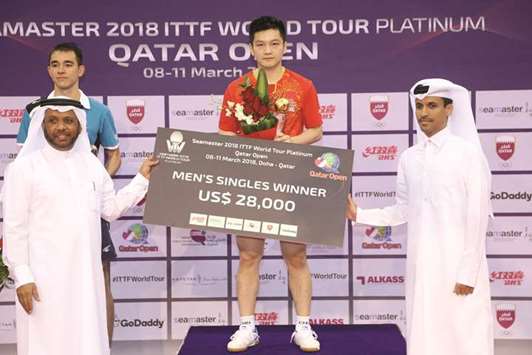 Qatar Olympic Committee secretary-general Jassim al-Buenain (right) presents the winners cheque to Chinau2019s Fan Zhendong, who won the menu2019s singles title at the ITTF World Tour Platinum Qatar Open yesterday. President of Qatar Table Tennis Association Khalil bin Ahmed al-Mohannadi (left) and runner-up Hugo Calderano of Brazil are also seen. PICTURES: Noushad Thekkayil