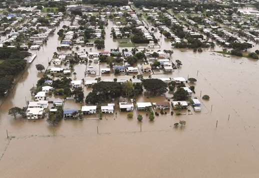 Houses can be seen surrounded by flood waters in the town of Ingham, located in North Queensland, Australia, yesterday.
