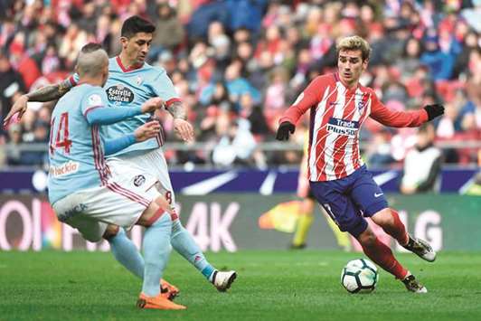 Atletico Madridu2019s Antoine Griezmann (right) vies for the ball with Celta Vigou2019s Stanislav Lobotka (left) and Pedro Pablo Hernandez during the Spanish La Liga match at the Wanda Metropolitan stadium in Madrid yesterday. (AFP)