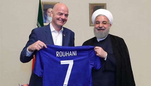 Iranian President Hassan Rouhani and FIFA President Gianni Infantino hold a football shirt with Rouhani's name during Infantino's visit to Tehran on Thursday.