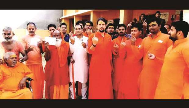 People wearing saffron clothes come out of a polling booth after casting their votes in Phulpur, Uttar Pradesh, yesterday.