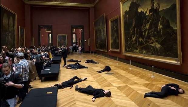 Members of the environmental activist group '350.org' lie on the floor in front of Theodore Gericault's painting ,The Raft of the Medusa, at The Louvre Museum in Paris