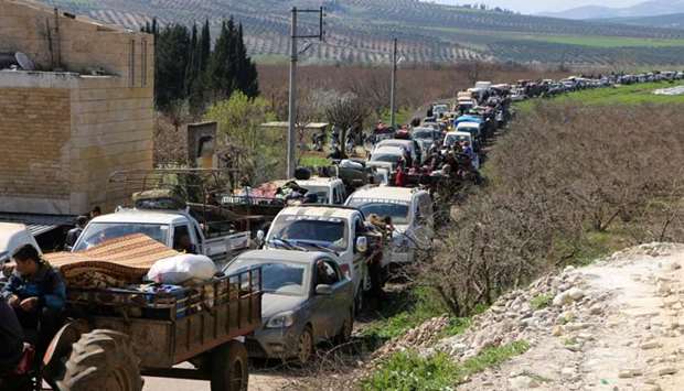 Syrian civilians ride their cars through Ain Dara in Syria's northern Afrin region as they flee Afrin city on March 12, 2018 amid battles between Turkish-backed forces and Kurdish fighters.
