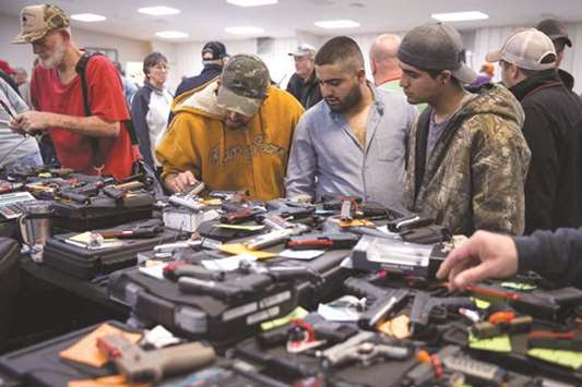 Visitors inspect guns at a Sweetwater Rifle and Pistol Club show at Nolan County Coliseum in Sweetwater, Texas.