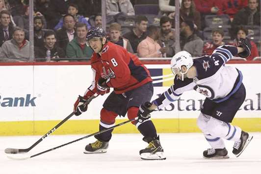 Alex Ovechkin (left) of Washington Capitals skates past Josh Morrissey of Winnipeg Jets during the NHL match in Washington, DC, on Monday. (AFP)