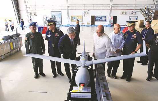 Defence Secretary Delfin Lorenzana and US ambassador to the Philippines Sung Y Kim inspect the ScanEagle Unmanned Aerial Vehicles during a transfer from the US to the Philippine Air Force at the Villamor Air Base in Pasay city, Metro Manila, yesterday.