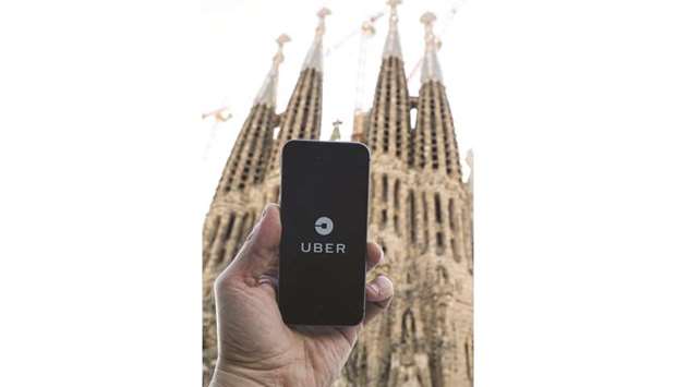 A smartphone displays the Uber app with Barcelonau2019s Sagrada  Familia in the background. Uber said it was back in Barcelona with 120 professional drivers after it was forced out three years ago.
