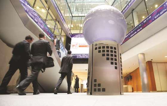 Visitors pass a sign inside the London Stock Exchange headquarters. The FTSE 100 closed down 0.1% to 7,132.69 points yesterday.