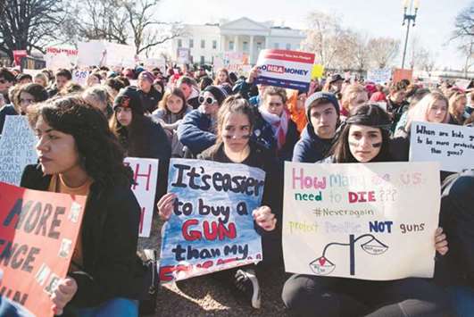Thousands of local students sit for 17 minutes, in honour of the 17 students killed last month in a high school shooting in Florida, during a nationwide student walkout for gun control in front the White House in Washington, DC.