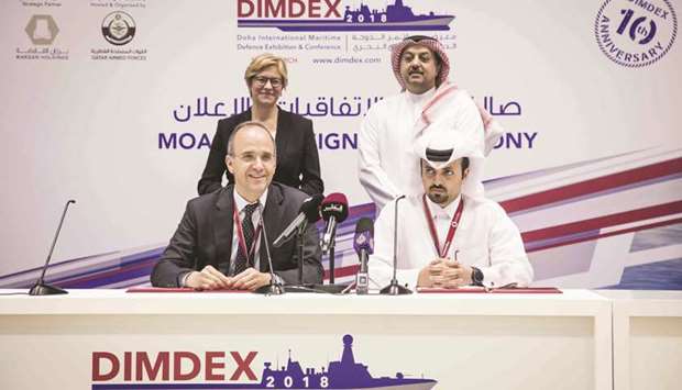 HE the Deputy Prime Minister and Minister of State for Defence Affairs Dr Khalid bin Mohamed al-Attiyah and the Italian Minister of Defence Roberta Pinotti look on as top officials of Barzan Holdings and Beretta Holding sign the agreement at Dimdex 2018.