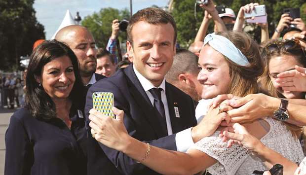 French President Emmanuel Macron poses for a selfie with Paris Mayor Anne Hidalgo (left) during a visit to a site on the Pont Alexandre III in Paris.