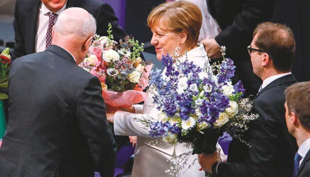 German Chancellor Angela Merkel is offered flowers after she was re-elected at the Bundestag in Berlin.