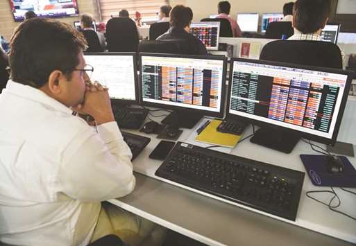 Traders are seen at the Bombay Stock Exchange. The Sensex dropped 0.4% to 33,685.54 yesterday, its third day of retreat.
