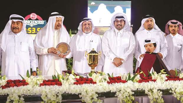 Qatar Racing and Equestrian Club (QREC) general manager Nasser Sherida al-Kaabi (fourth from left) with the guests during the prize distribution ceremony for the Late Abdulaziz Al Fuhaid Cup at the QREC yesterday. Sheikh Faisal bin Hamad bin Jassim al-Thani-owned Topsy Turvy, trained by Ibrahim al-Malki, won the dirt feature. At bottom, owner Sheikh Faisal bin Hamad bin Jassim al-Thani (right) congratulates jockey Eduardo Pedroza after the victory astride Topsy Turvy in the Late Abdulaziz Al Fuhaid Cup at the Qatar Racing and Equestrian Club. PICTURES: Juhaim