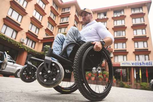 Wheelchair-bound Australian Scott Doolan makes his way along a street in Kathmandu.